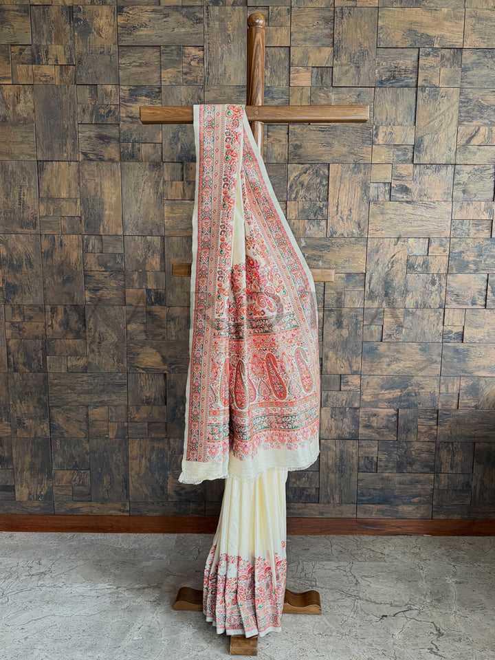 Luxurious off-white Pashmina raw silk saree featuring intricate embossed thread work, perfect for a refined and graceful look