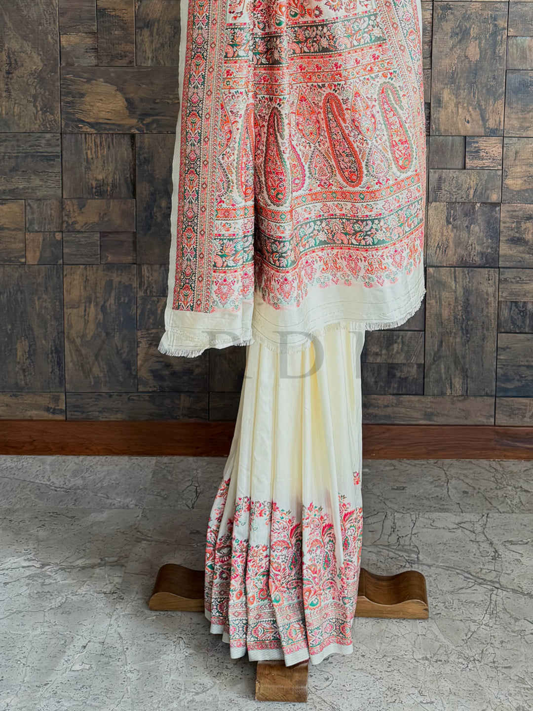 Sophisticated off-white saree in premium Pashmina raw silk, adorned with exquisite embossed thread work for a regal appeal.