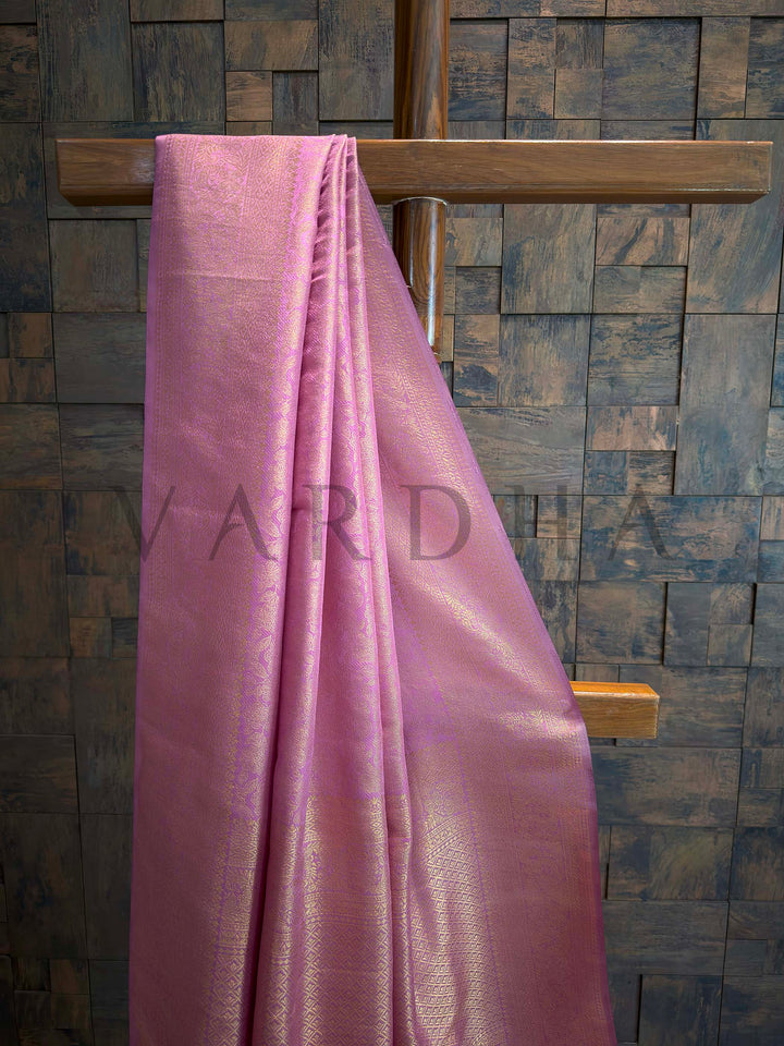 Close-up of lavender-pink saree body showing continuous gold zari floral jaal with subtle sheen and lattice transition, ideal for festive styling