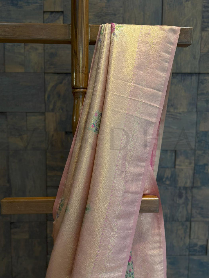Detailed border and pleats showing pastel sheen and floral woven accents in zari for elegant occasion dressing., Full view of pastel saree draped over stand, highlighting kalamkari artistry and golden border elegance