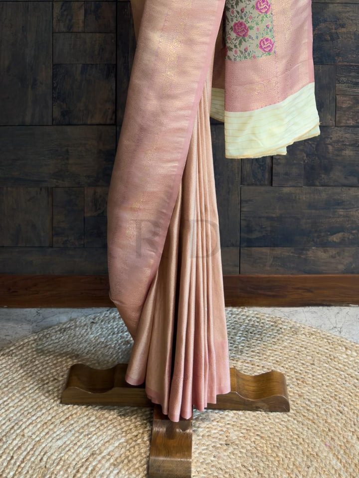 Floral buta motifs woven into pastel peach art silk fabric with tonal sheen and smooth flow., Zoomed view of pallu showcasing multi-color floral panel and cream border for contrast styling