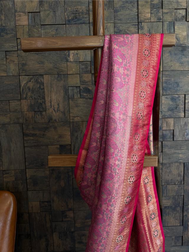 Zari-woven pink saree with Kalamkari peacock motifs and contrast pallu, ideal for family functions. Elegant pink saree in art silk with floral zari borders and detailed Kalamkari work throughout.