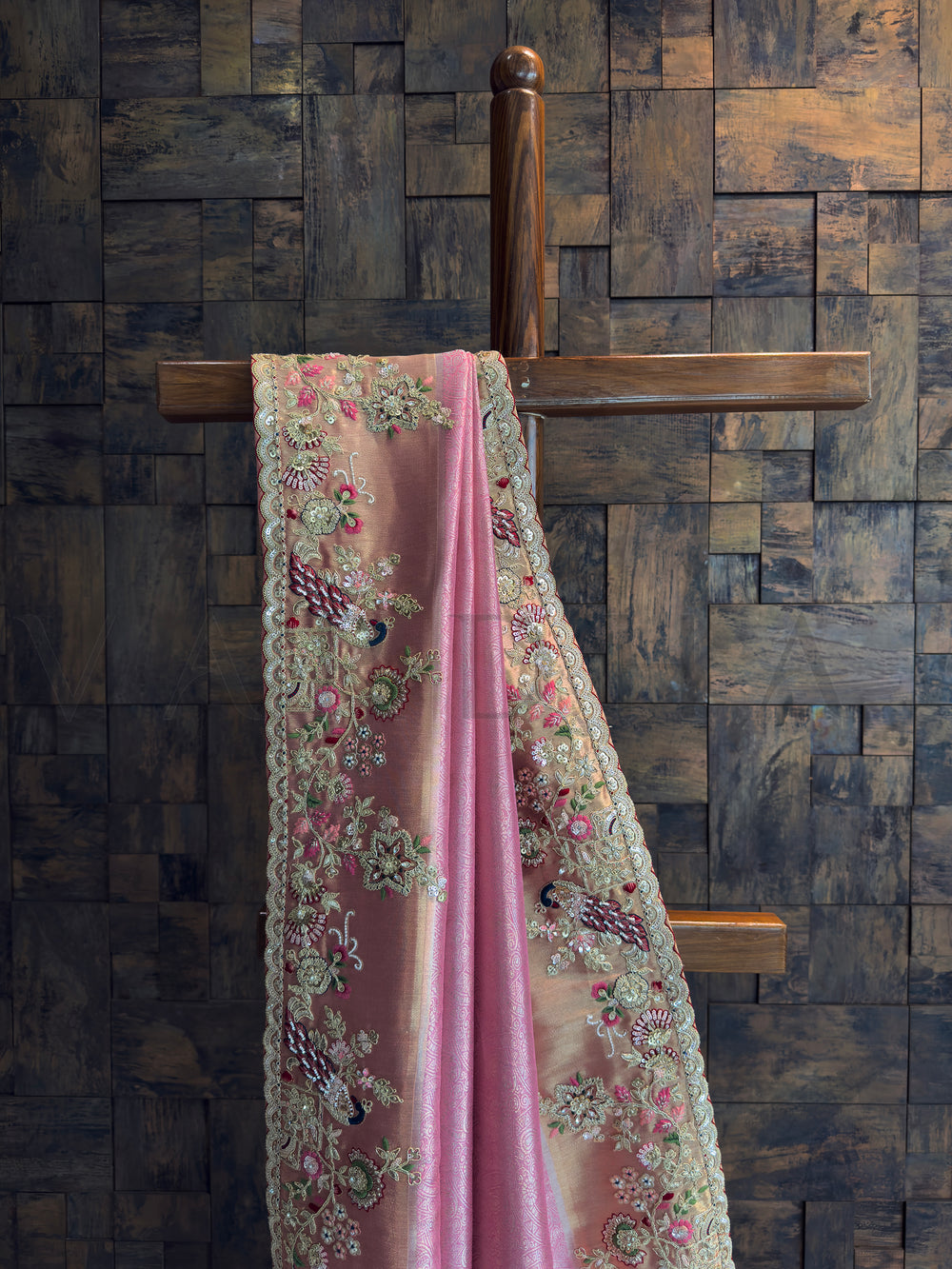 Close-up of pink tissue silk saree featuring zari, sequins, and bead embroidery with peacock motifs.