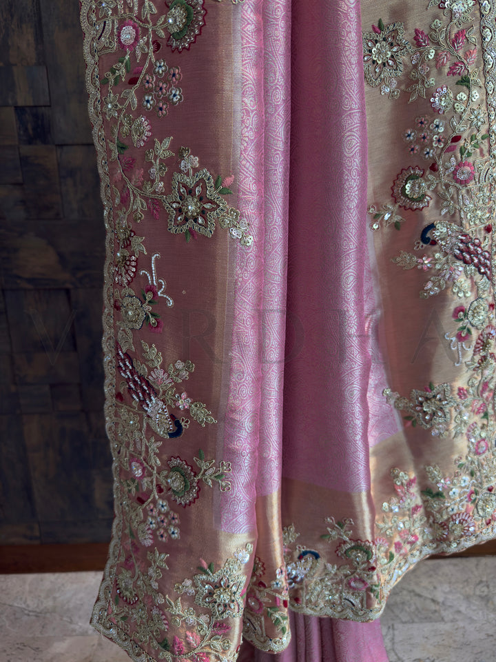 Bridal pink Kanjivaram saree featuring peacocks, blossoms, and beadwork in gold embroidery.