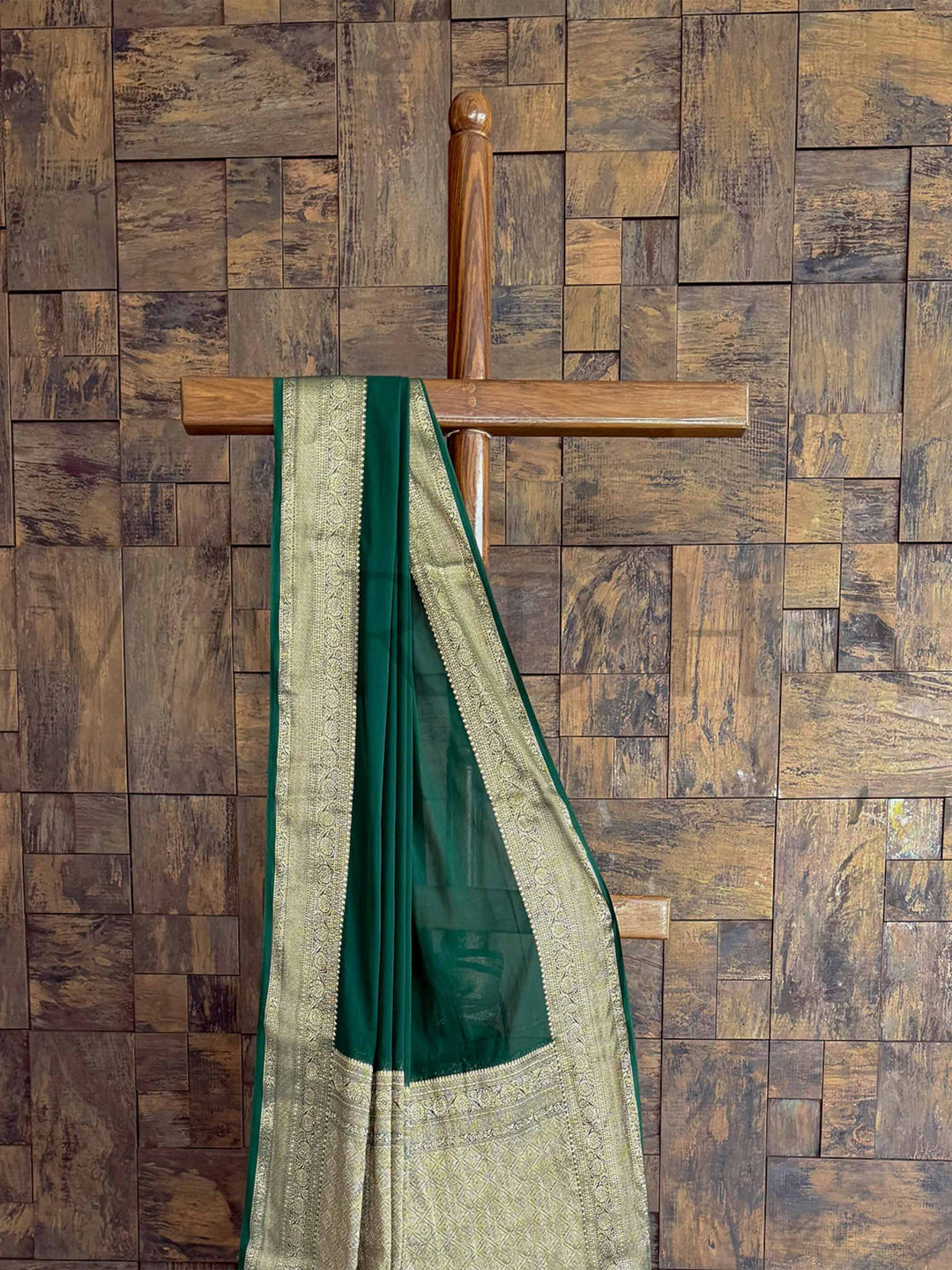 A classic green georgette saree with shimmering gold zari accents, elegantly draped to highlight its refined beauty. Perfect for weddings, festive gatherings, and evening wear.