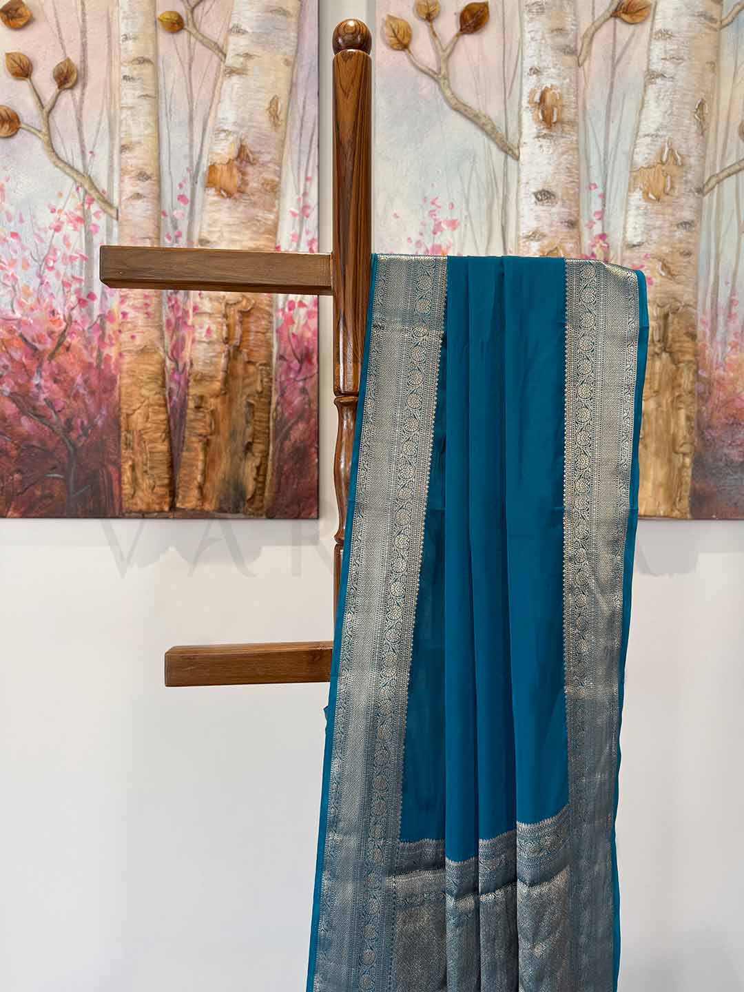 An exquisite feather-soft Rama green saree with a shimmering gold zari border, gracefully displayed to showcase its elegant drape and timeless beauty. A perfect blend of tradition and modern sophistication.