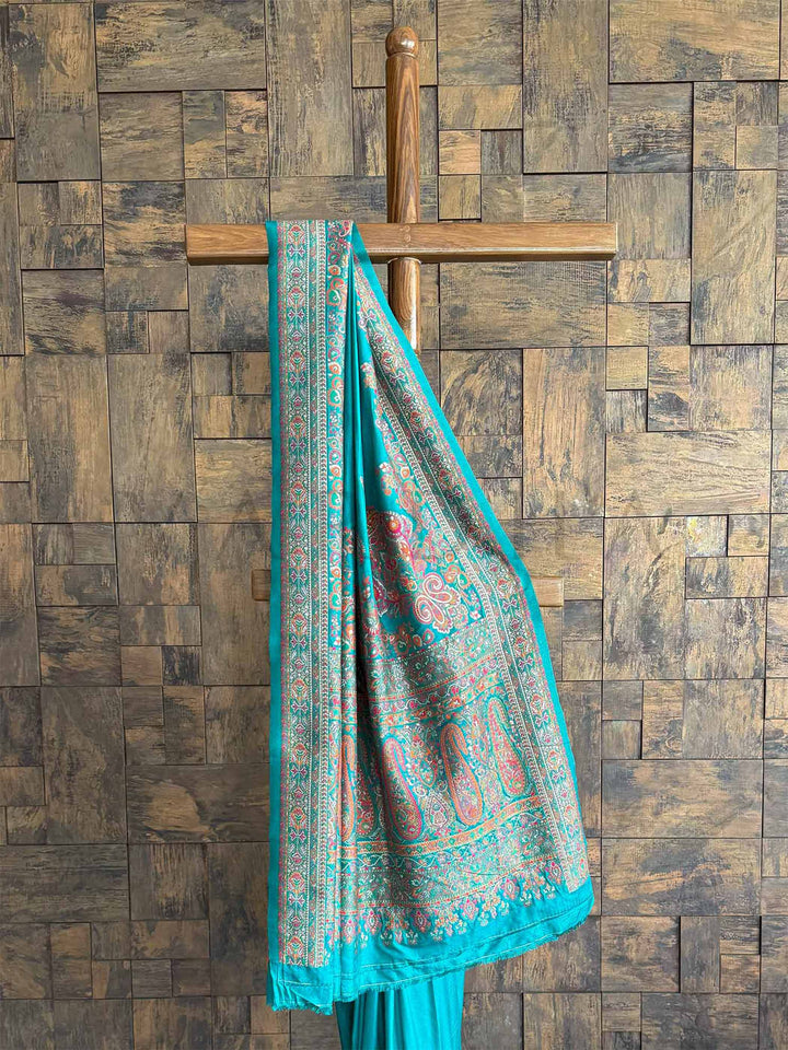 Luxurious Rama blue saree in Pashmina raw silk, featuring delicate embossed thread embroidery for a refined and regal appeal.