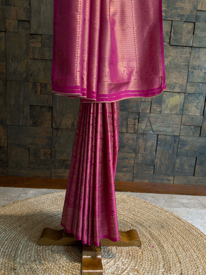 Lower half view highlighting diamond brocade border in gold zari over rani pink base with neatly stacked pleats and sheen