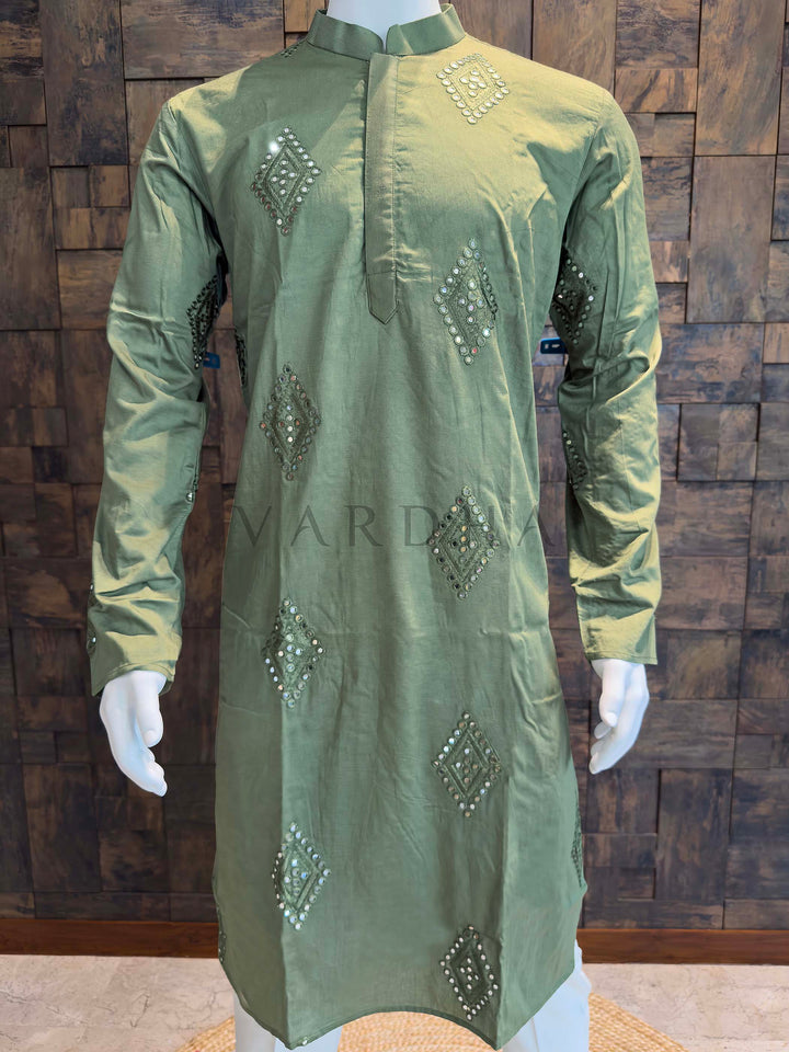 Green embroidered kurta on a mannequin against a wooden paneled wall. Front panel detail of men’s viscose kurta featuring evenly spaced mirror work butis with tonal thread accents and a gentle fabric sheen.