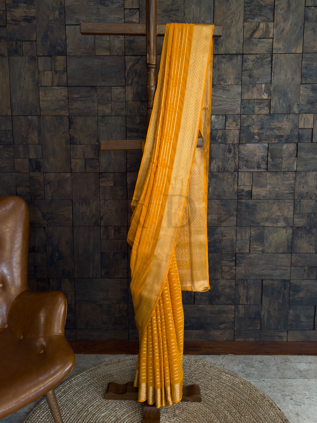 Sunshine yellow georgette saree with gold zari striped work and lightweight feathersoft texture, ideal for haldi and day functions. Lower pleats view of yellow feathersoft saree with golden border and striped zari details flowing with ease