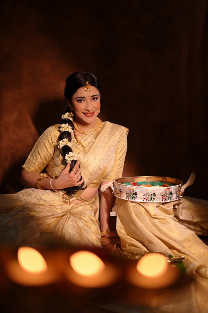 Nyra Banerjee in traditional Kanjivaram Silk Saree holding a decorative pot with candles in the foreground