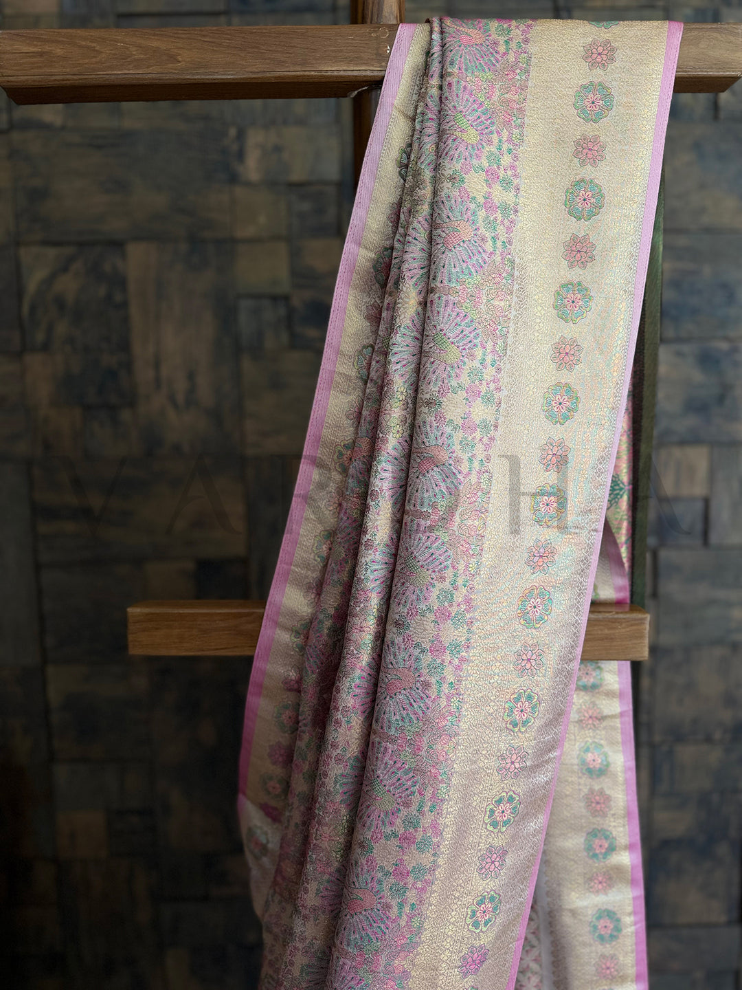 Traditional white woven saree with intricate floral Kalamkari print and contrast blouse. Soft white saree with luxurious pink border and gold zari accents for festive wear.