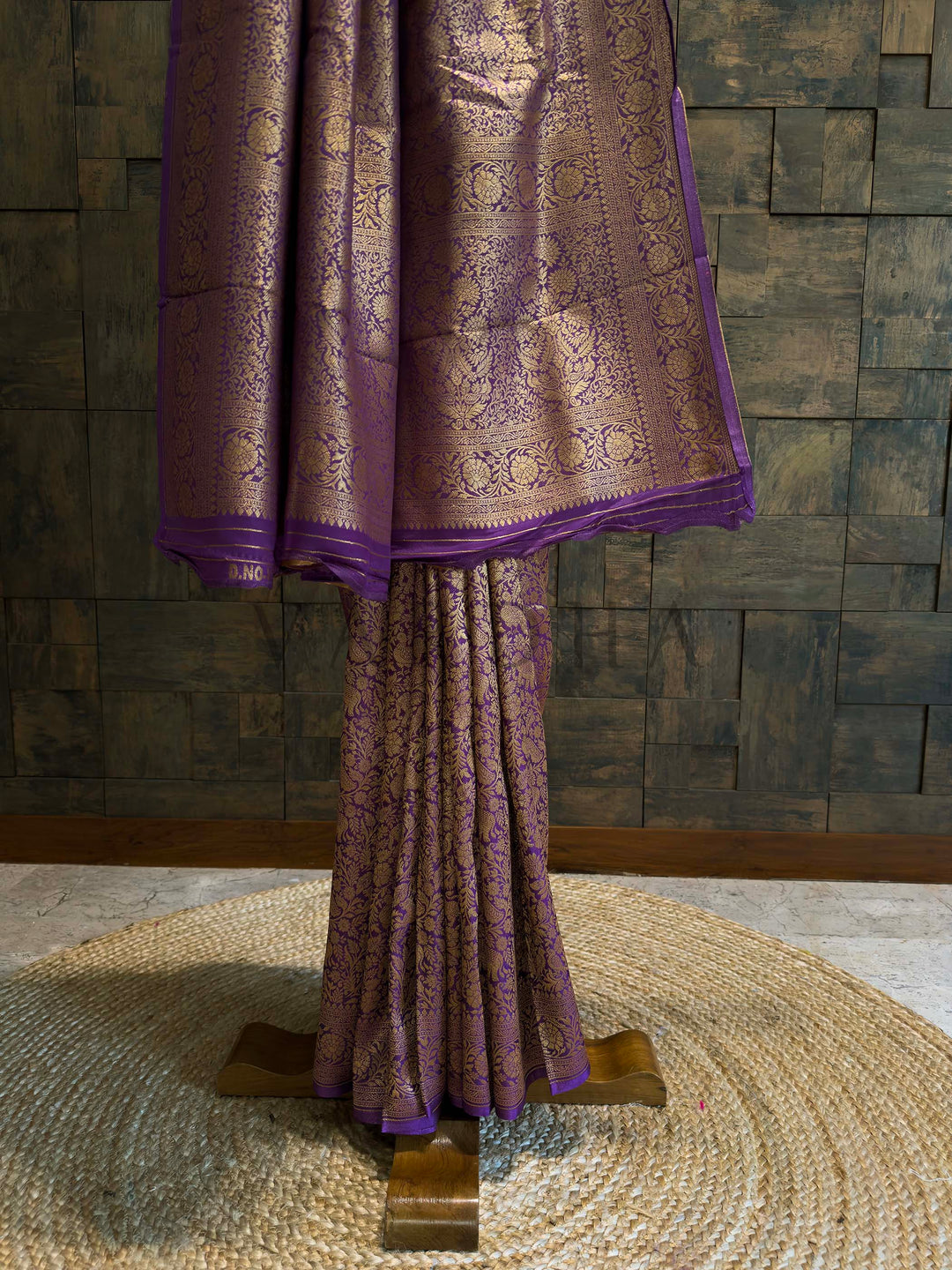 Lower pleats of purple saree with all-over floral jaal and zari border detail