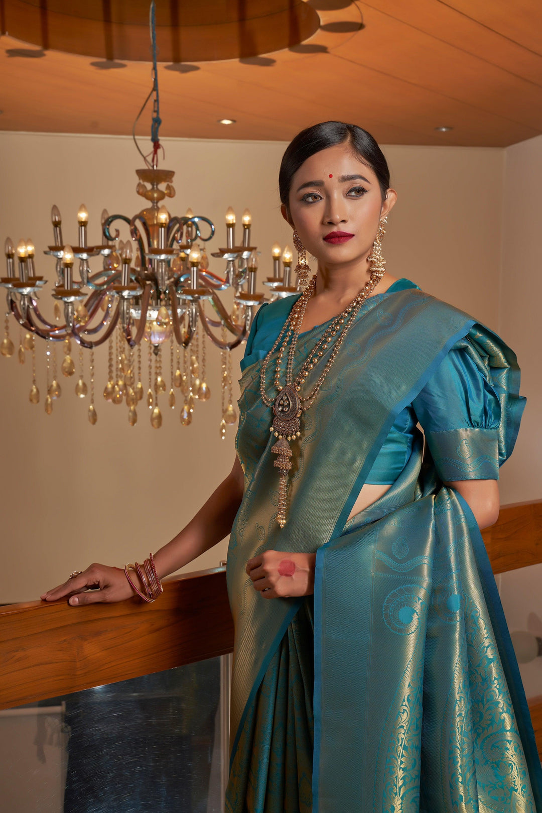 -up shot of the intricate gold zari weaving along the saree border and pallu.