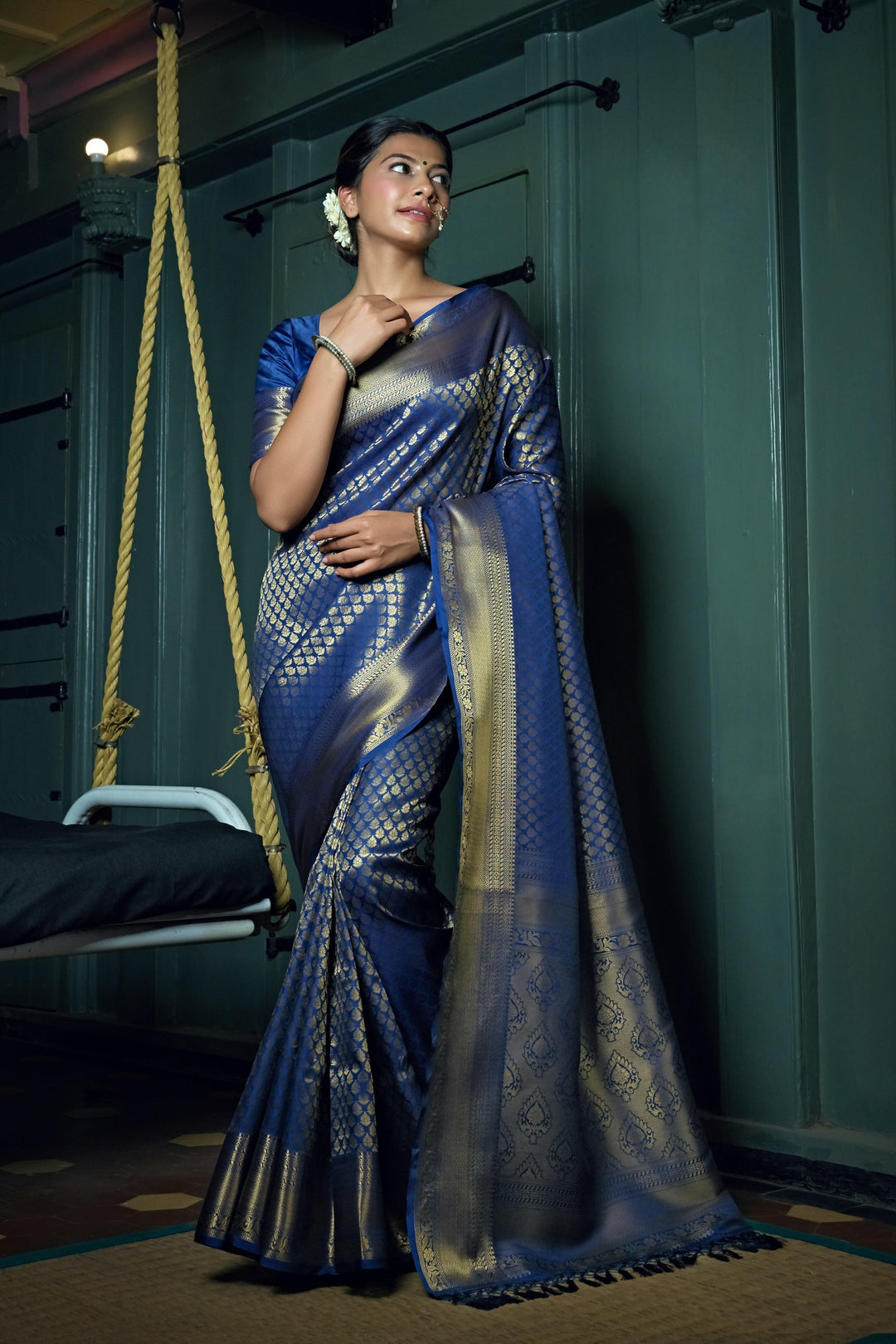 Flat lay of saree showing vibrant blue fabric with traditional patterns.