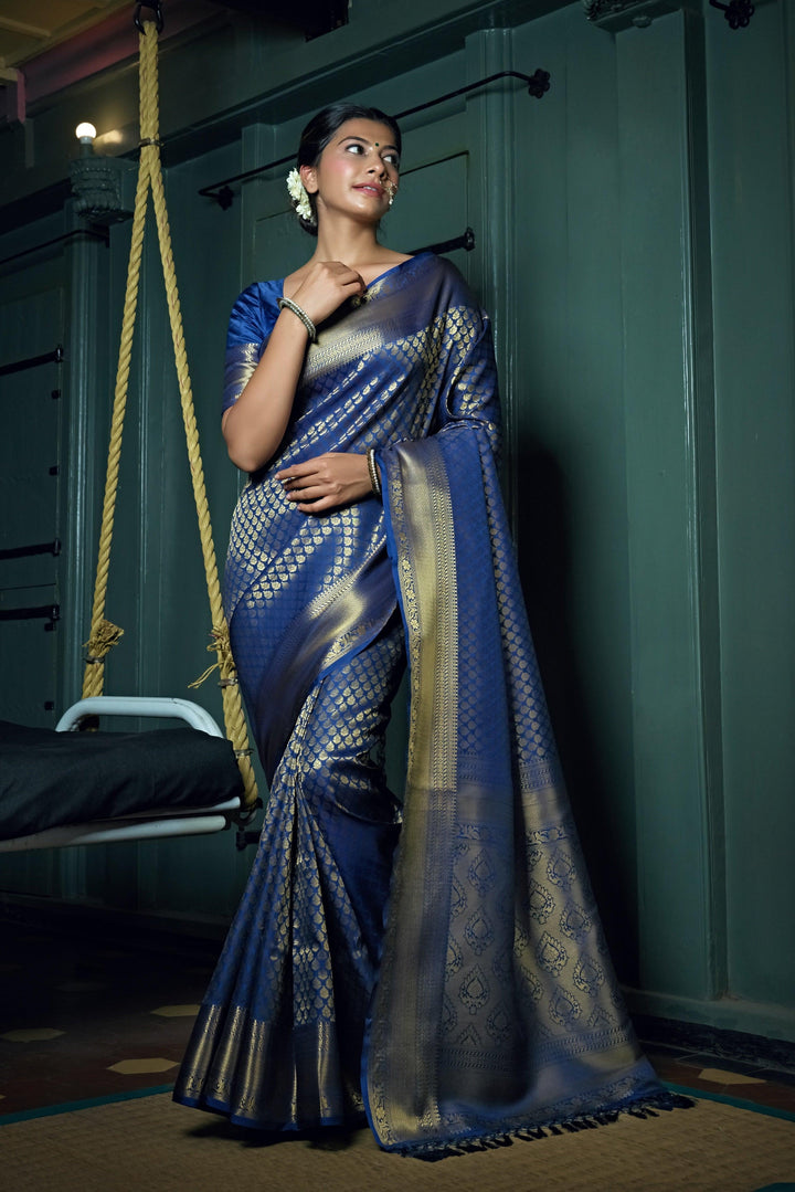 Flat lay of saree showing vibrant blue fabric with traditional patterns.