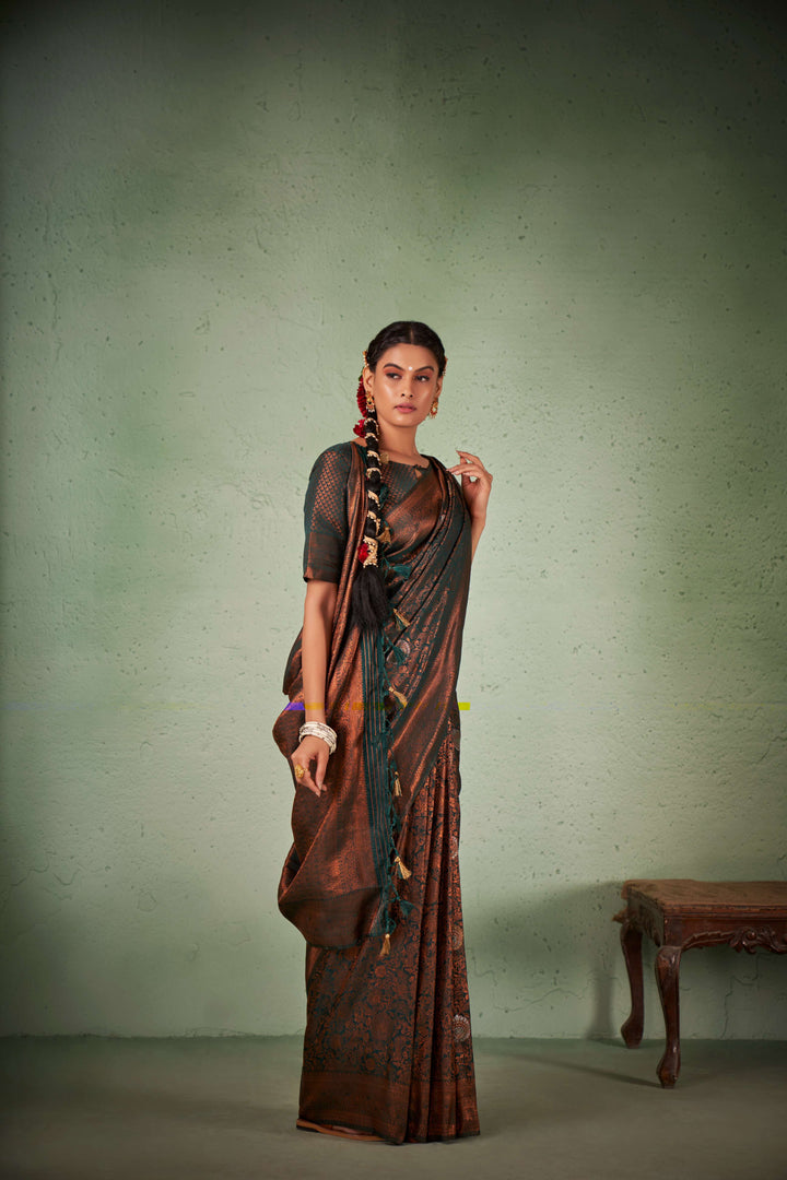 Model in a phthalo green saree with luminous copper zari detailing.