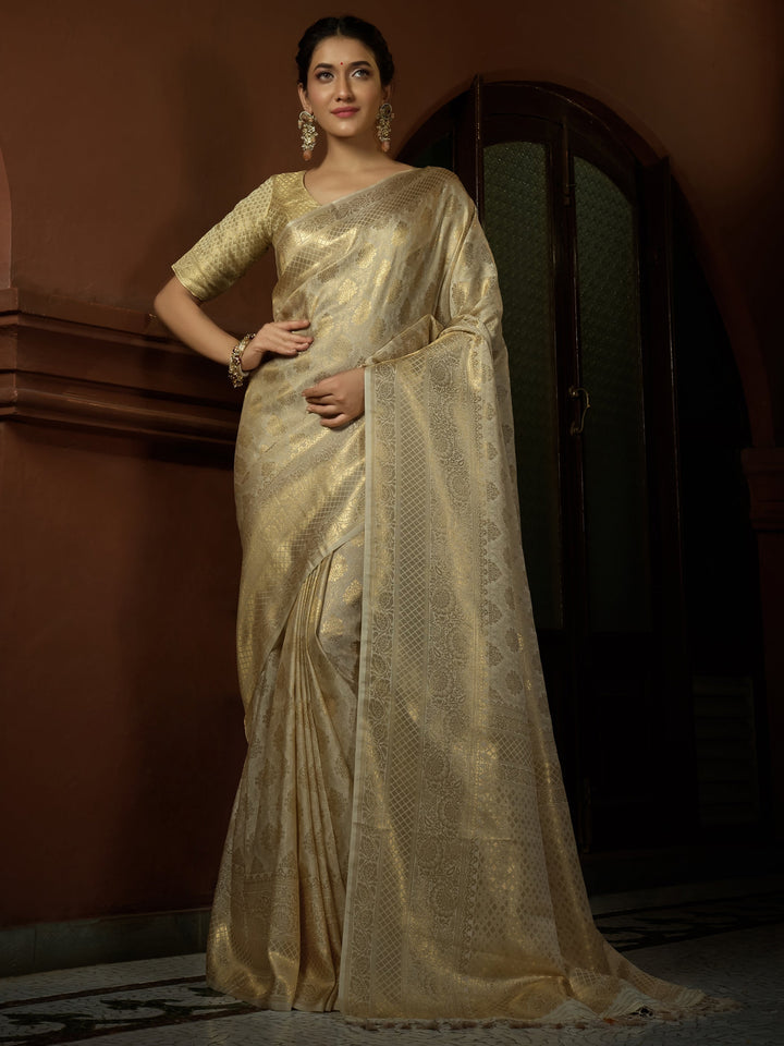 Model draped in Vanilla White Kanjeevaram Silk Saree with golden zari work, showcasing elegant pleats and traditional styling inspired by Pooja Banerjee.