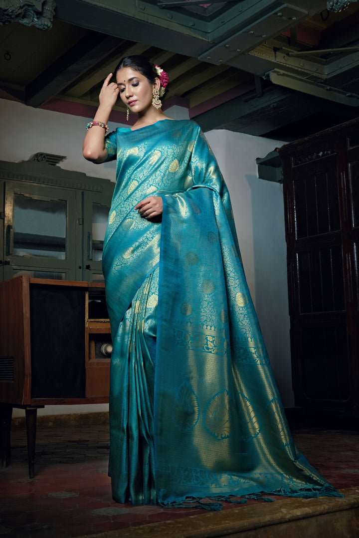 Front view of a model wearing the Sky Teal Blue Kanjivaram Silk Saree with gold zari detailing.