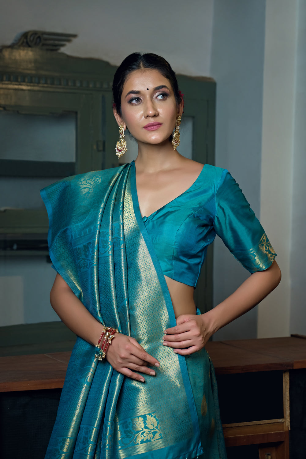 Close-up of the saree’s intricate gold zari work on the border and pallu.