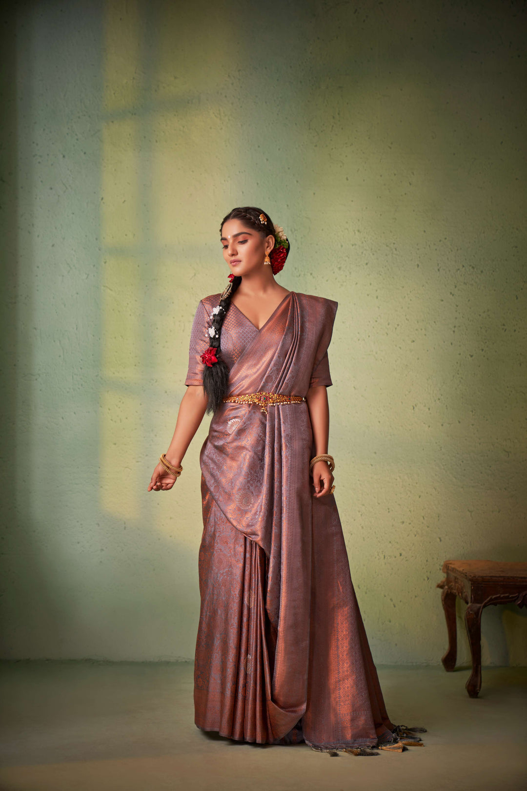 Model styling traditional saree with antique jewelry.