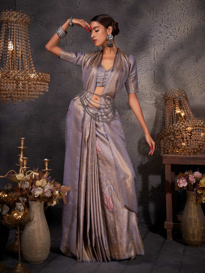 Model wearing slate grey Kanjeevaram saree with gold, silver, and copper zari detailing across the body and pallu.