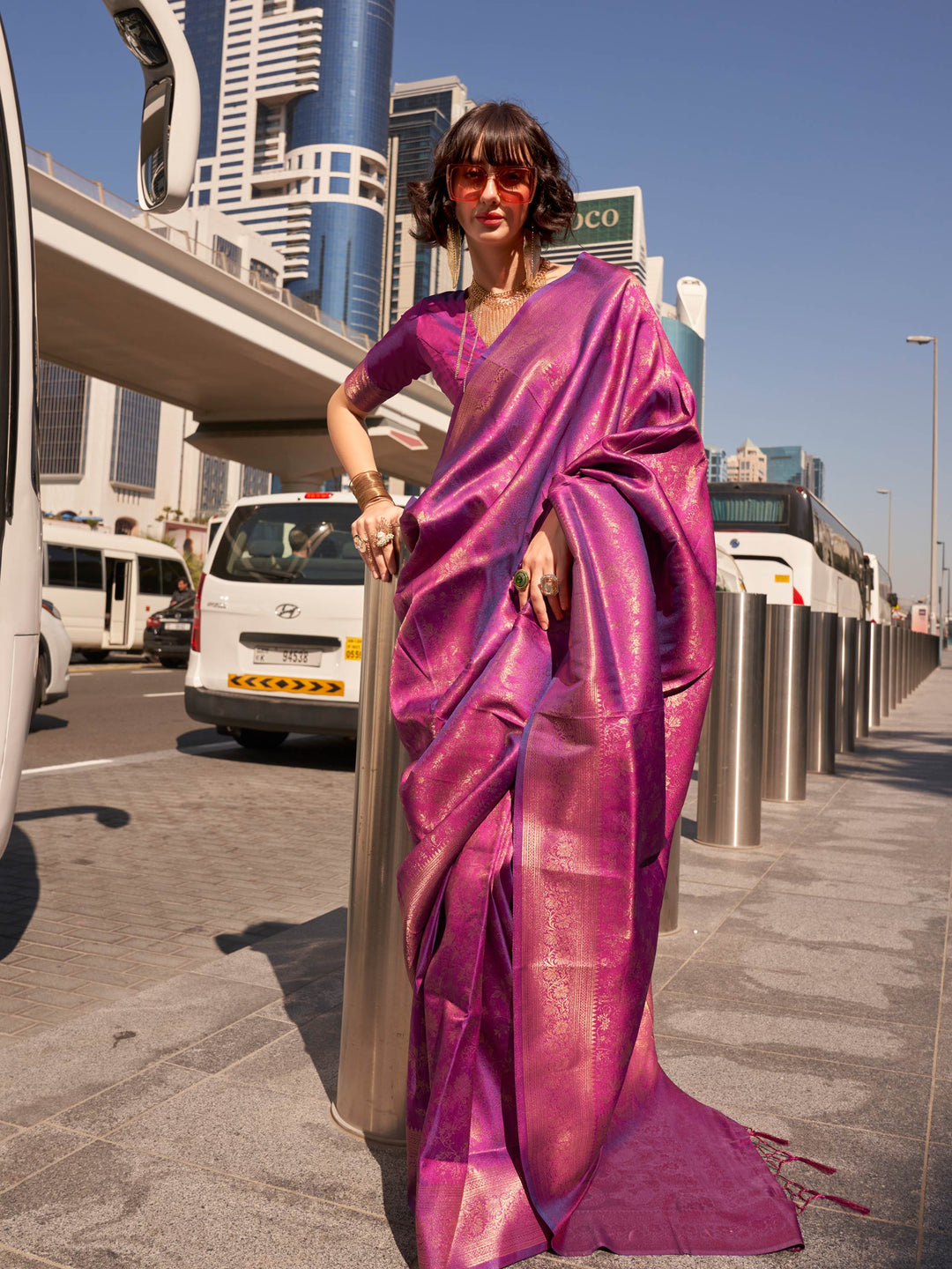 Purple Kanjivaram Silk Saree with golden woven zari detailing, styled for party wear and festive fashion. Radiant purple silk saree with glossy finish and gold jacquard motifs for statement ethnic dressing.