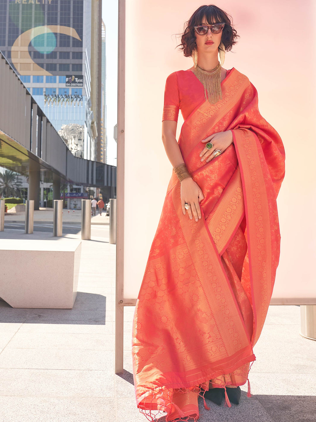 Coral–Gold kanjivaram silk saree with gold zari work, styled for traditional functions. Elegant Coral–Gold silk saree with woven borders and festive-ready pallu.