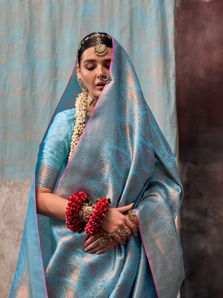 Blue and Peach two-tone handwoven silk saree with contrast selvage border and paisley weaving. This image captures the model styling perspective with complete saree ensemble displayed, ideal for visualizing festive elegance, designer appeal, and modern styling inspiration. Perfect for online shoppers seeking detailed previews before purchase, enhancing saree visual merchandising and SEO-rich product display strategy.                                                                                            