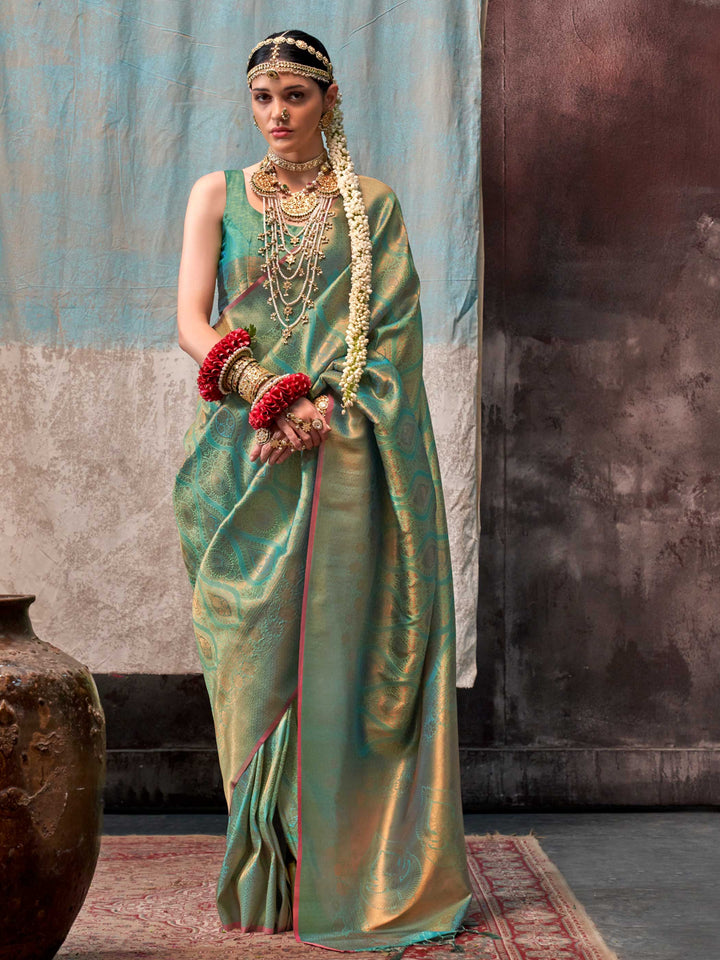 Green and Gold two-tone handwoven silk saree with contrast selvage border and paisley weaving. This image captures the front drape view highlighting pallu fall and pleats alignment, ideal for visualizing festive elegance, designer appeal, and modern styling inspiration. Perfect for online shoppers seeking detailed previews before purchase, enhancing saree visual merchandising and SEO-rich product display strategy.                                                                                               