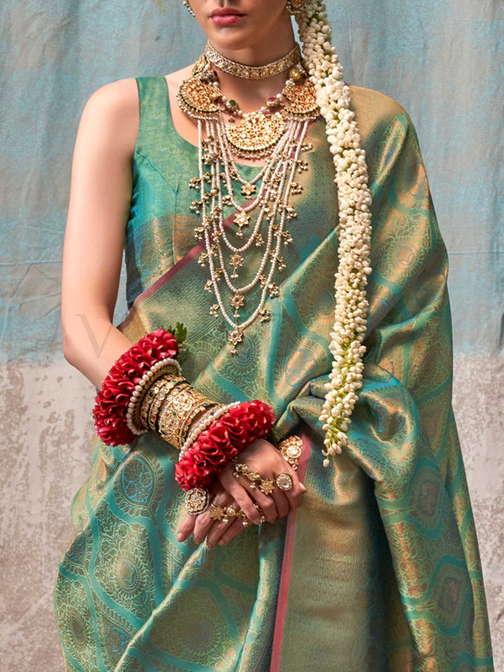 Green and Gold two-tone handwoven silk saree with contrast selvage border and paisley weaving. This image captures the zoomed texture view illustrating fabric weave and print clarity, ideal for visualizing festive elegance, designer appeal, and modern styling inspiration. Perfect for online shoppers seeking detailed previews before purchase, enhancing saree visual merchandising and SEO-rich product display strategy.                                                                                             