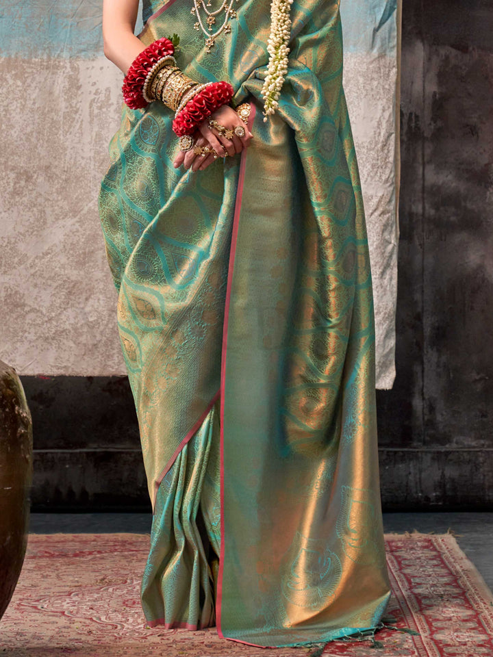 Green and Gold two-tone handwoven silk saree with contrast selvage border and paisley weaving. This image captures the back drape focus revealing pallu finesse and motif richness, ideal for visualizing festive elegance, designer appeal, and modern styling inspiration. Perfect for online shoppers seeking detailed previews before purchase, enhancing saree visual merchandising and SEO-rich product display strategy.                                                                                                 