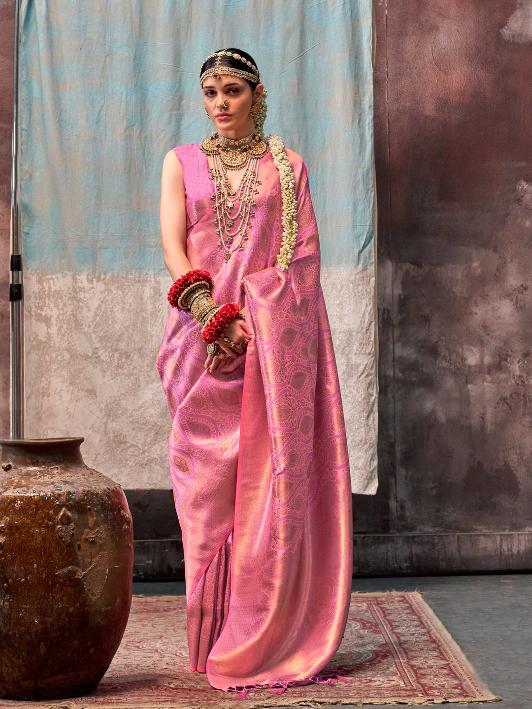 Pink and Rose Gold two-tone handwoven silk saree with contrast selvage border and paisley weaving. This image captures the front drape view highlighting pallu fall and pleats alignment, ideal for visualizing festive elegance, designer appeal, and modern styling inspiration. Perfect for online shoppers seeking detailed previews before purchase, enhancing saree visual merchandising and SEO-rich product display strategy.                                                                                           