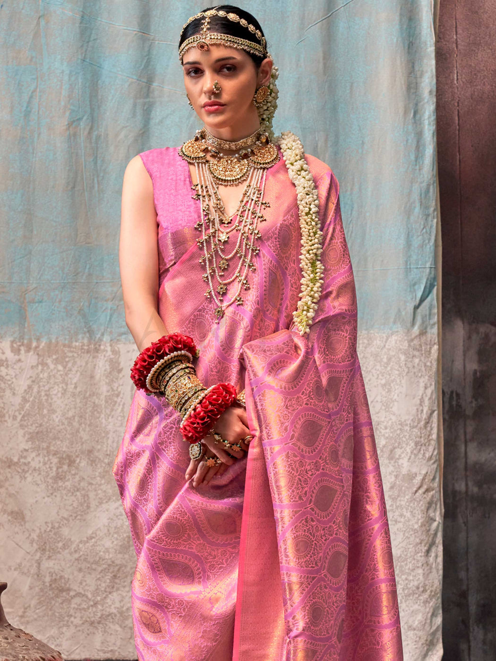 Pink and Rose Gold two-tone handwoven silk saree with contrast selvage border and paisley weaving. This image captures the side angle view showcasing blouse styling and zari border detail, ideal for visualizing festive elegance, designer appeal, and modern styling inspiration. Perfect for online shoppers seeking detailed previews before purchase, enhancing saree visual merchandising and SEO-rich product display strategy.                                                                                        