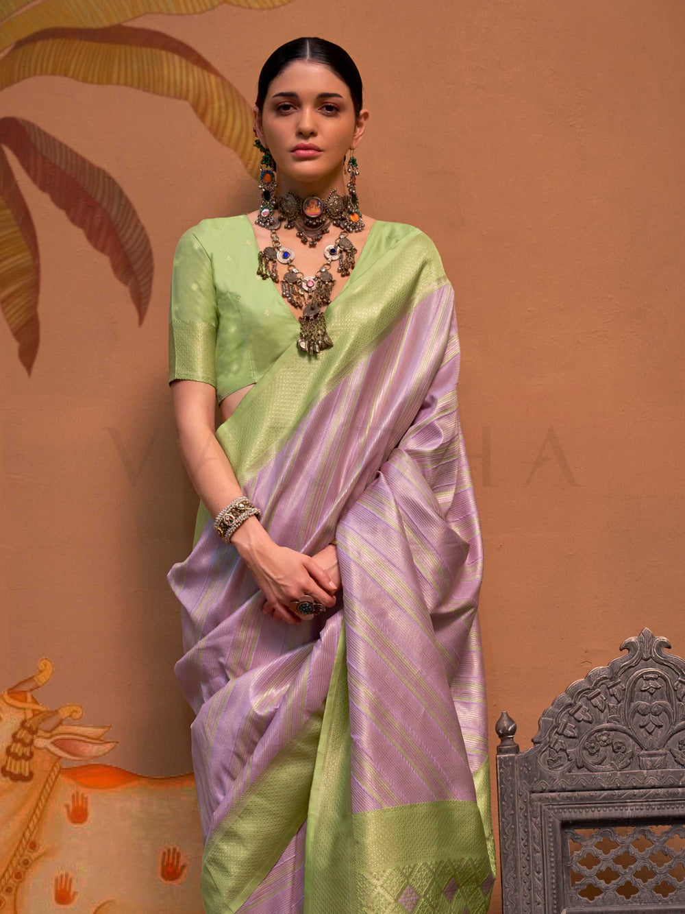 Lavender and Pista Green striped silk saree with handloom weave and checked pallu. Ideal for sangeet functions like sister of bride, styled with heritage jewelry and temple-inspired accessories. This image captures the side angle view showcasing blouse styling and zari border detail, ideal for visualizing festive elegance, designer appeal, and modern styling inspiration. Perfect for online shoppers seeking detailed previews before purchase, enhancing saree visual merchandising and SEO-rich product display s