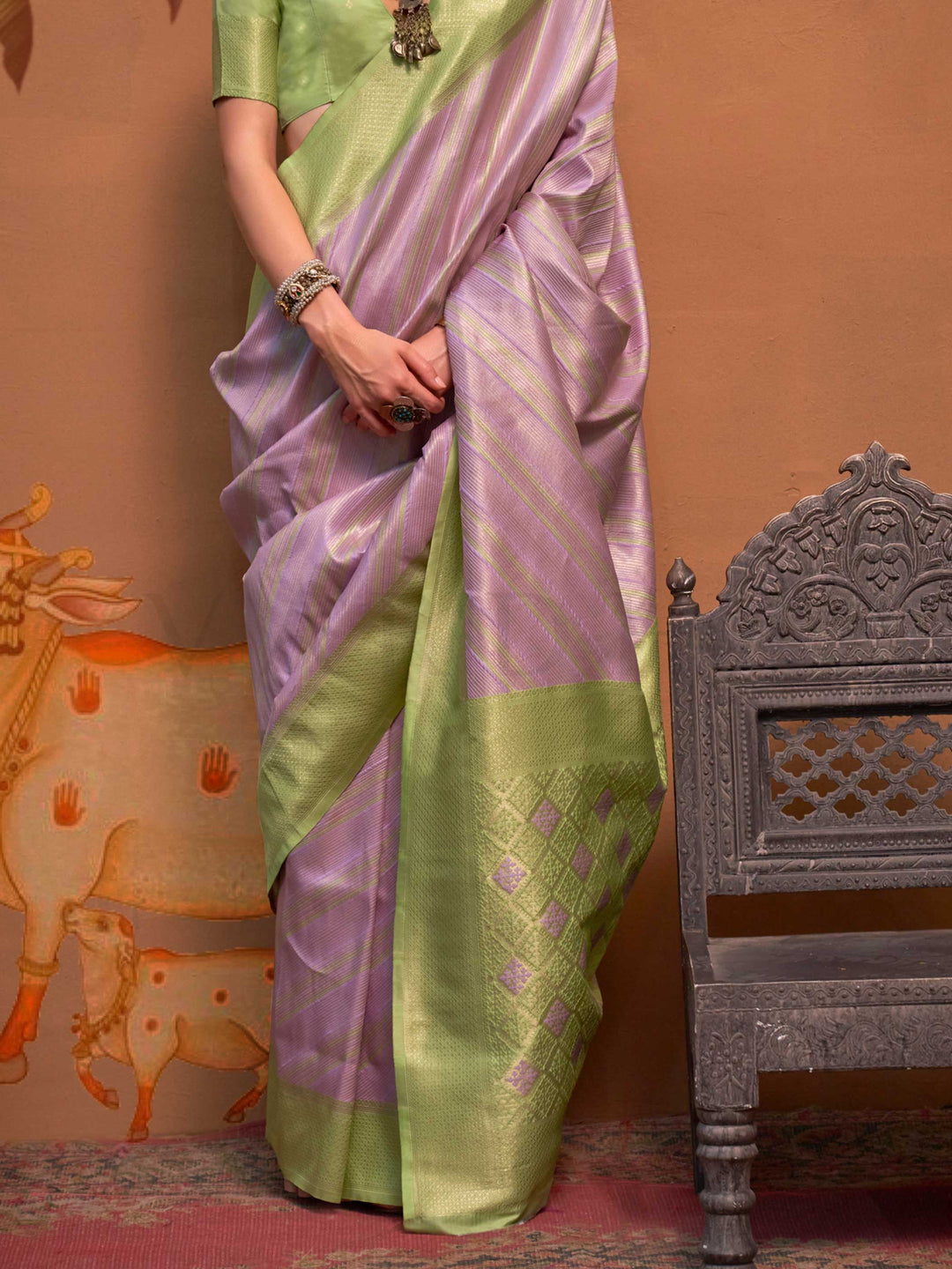 Lavender and Pista Green striped silk saree with handloom weave and checked pallu. Ideal for sangeet functions like sister of bride, styled with heritage jewelry and temple-inspired accessories. This image captures the back drape focus revealing pallu finesse and motif richness, ideal for visualizing festive elegance, designer appeal, and modern styling inspiration. Perfect for online shoppers seeking detailed previews before purchase, enhancing saree visual merchandising and SEO-rich product display strate