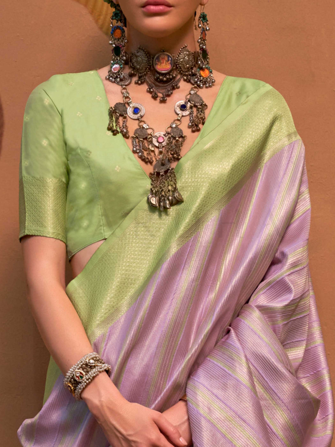 Lavender and Pista Green striped silk saree with handloom weave and checked pallu. Ideal for sangeet functions like sister of bride, styled with heritage jewelry and temple-inspired accessories. This image captures the zoomed texture view illustrating fabric weave and print clarity, ideal for visualizing festive elegance, designer appeal, and modern styling inspiration. Perfect for online shoppers seeking detailed previews before purchase, enhancing saree visual merchandising and SEO-rich product display st