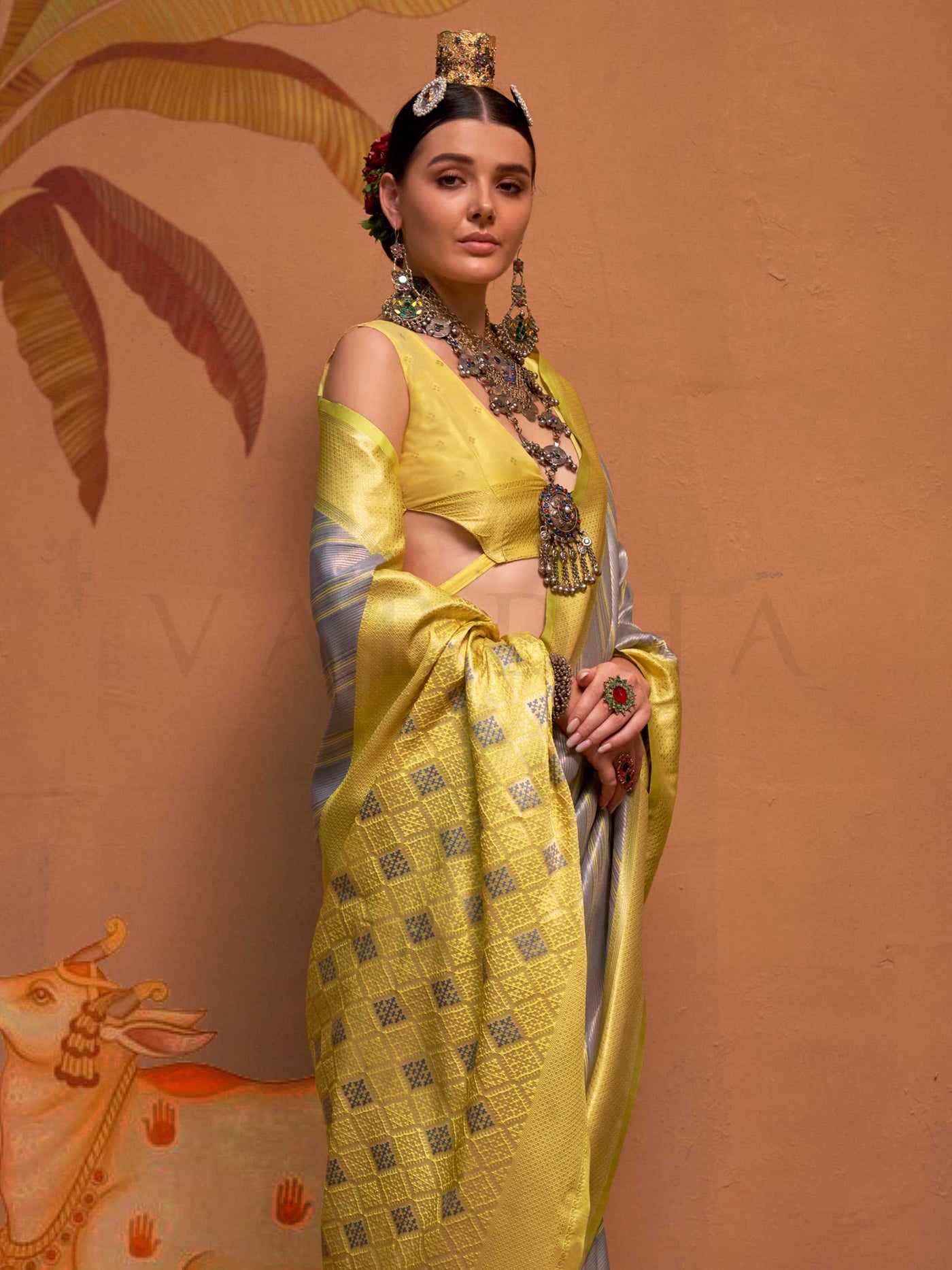 Lemon Yellow and Grey striped silk saree with handloom weave and checked pallu. Ideal for bollywood functions like editorial fashion, styled with heritage jewelry and temple-inspired accessories. This image captures the model styling perspective with complete saree ensemble displayed, ideal for visualizing festive elegance, designer appeal, and modern styling inspiration. Perfect for online shoppers seeking detailed previews before purchase, enhancing saree visual merchandising and SEO-rich product display 