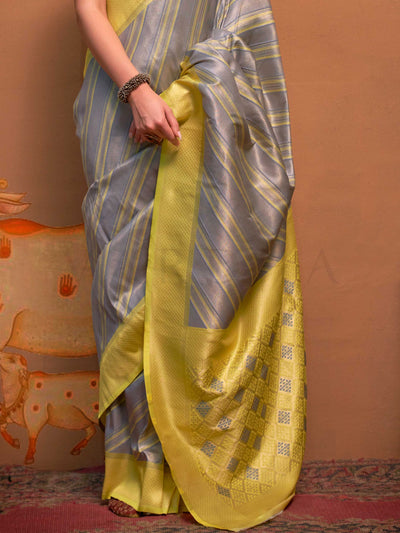 Lemon Yellow and Grey striped silk saree with handloom weave and checked pallu. Ideal for bollywood functions like editorial fashion, styled with heritage jewelry and temple-inspired accessories. This image captures the back drape focus revealing pallu finesse and motif richness, ideal for visualizing festive elegance, designer appeal, and modern styling inspiration. Perfect for online shoppers seeking detailed previews before purchase, enhancing saree visual merchandising and SEO-rich product display strat