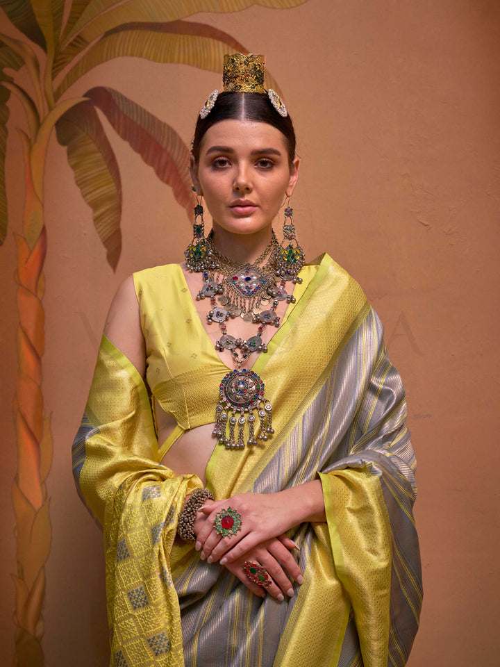 Lemon Yellow and Grey striped silk saree with handloom weave and checked pallu. Ideal for bollywood functions like editorial fashion, styled with heritage jewelry and temple-inspired accessories. This image captures the pleats close-up showing symmetry, color blending, and craftsmanship, ideal for visualizing festive elegance, designer appeal, and modern styling inspiration. Perfect for online shoppers seeking detailed previews before purchase, enhancing saree visual merchandising and SEO-rich product displ