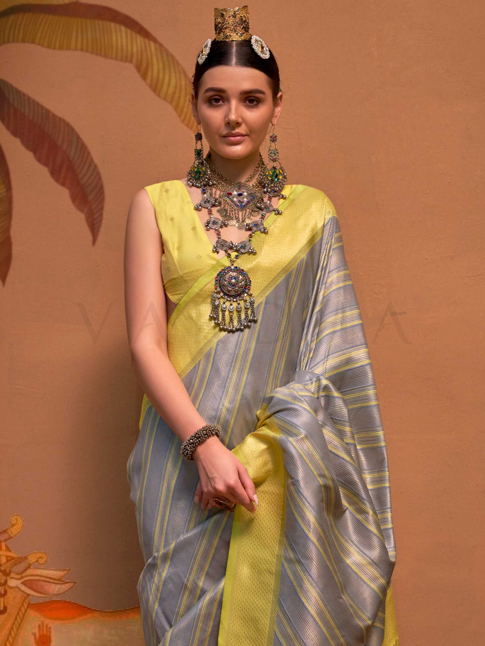 Lemon Yellow and Grey striped silk saree with handloom weave and checked pallu. Ideal for bollywood functions like editorial fashion, styled with heritage jewelry and temple-inspired accessories. This image captures the side angle view showcasing blouse styling and zari border detail, ideal for visualizing festive elegance, designer appeal, and modern styling inspiration. Perfect for online shoppers seeking detailed previews before purchase, enhancing saree visual merchandising and SEO-rich product display 