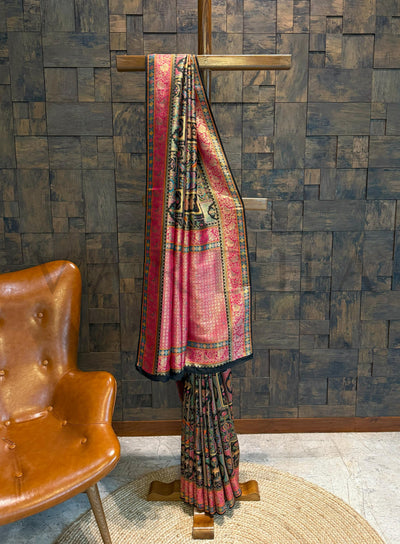 Traditional saree on a wooden stand against a textured wall with a brown chair.