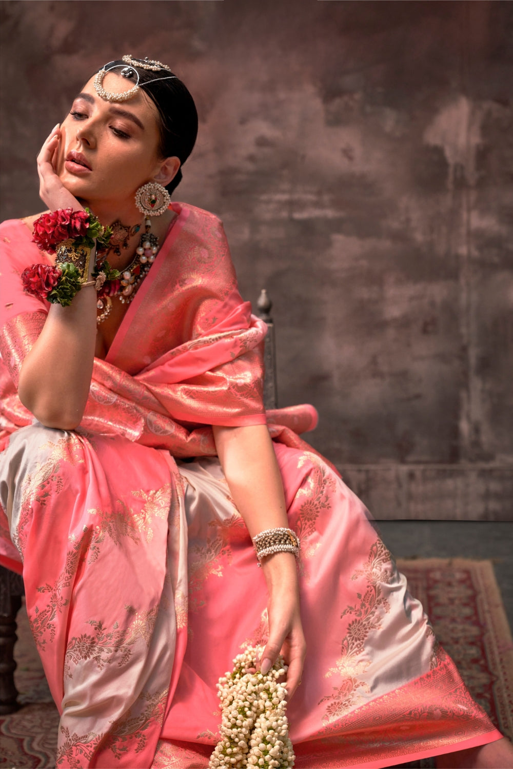 Blush Coral and Silver Rangkaat silk saree with temple borders, intricate zari pallu, and traditional wedding styling. Handloom drape perfect for festive season functions and karwachauth, diwali, styled with mogra, antique jewelry, and regal stance. This image captures the pleats close-up showing symmetry, color blending, and craftsmanship, ideal for visualizing festive elegance, designer appeal, and modern styling inspiration. Perfect for online shoppers seeking detailed previews before purchase, enhancing