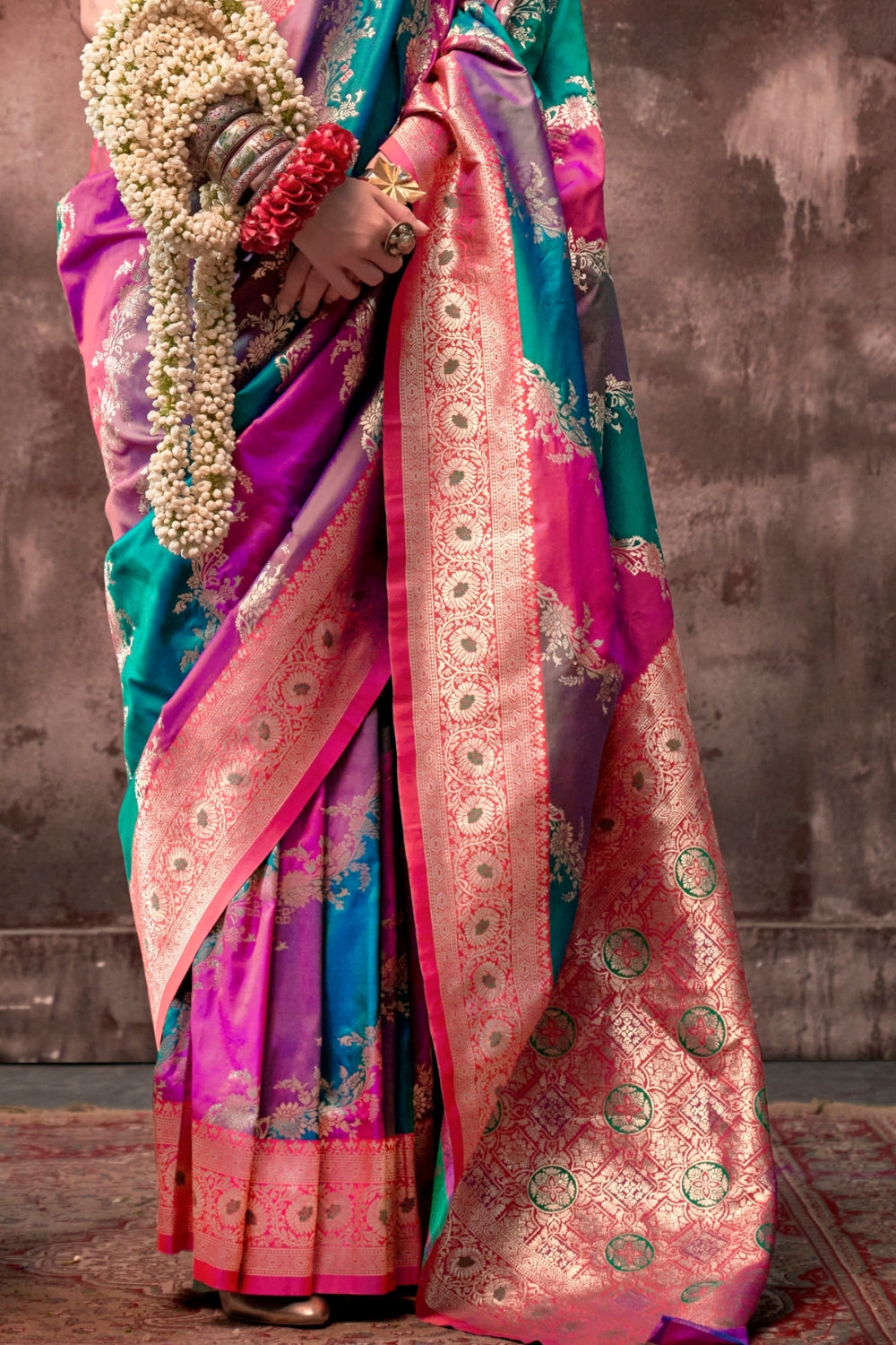Fuchsia and Teal Blue Rangkaat silk saree with temple borders, intricate zari pallu, and traditional wedding styling. Handloom drape perfect for bollywood functions and magazine shoot, styled with mogra, antique jewelry, and regal stance. This image captures the side angle view showcasing blouse styling and zari border detail, ideal for visualizing festive elegance, designer appeal, and modern styling inspiration. Perfect for online shoppers seeking detailed previews before purchase, enhancing saree visual 