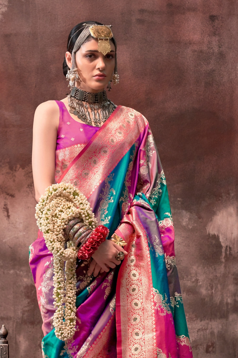 Fuchsia and Teal Blue Rangkaat silk saree with temple borders, intricate zari pallu, and traditional wedding styling. Handloom drape perfect for bollywood functions and magazine shoot, styled with mogra, antique jewelry, and regal stance. This image captures the back drape focus revealing pallu finesse and motif richness, ideal for visualizing festive elegance, designer appeal, and modern styling inspiration. Perfect for online shoppers seeking detailed previews before purchase, enhancing saree visual merch