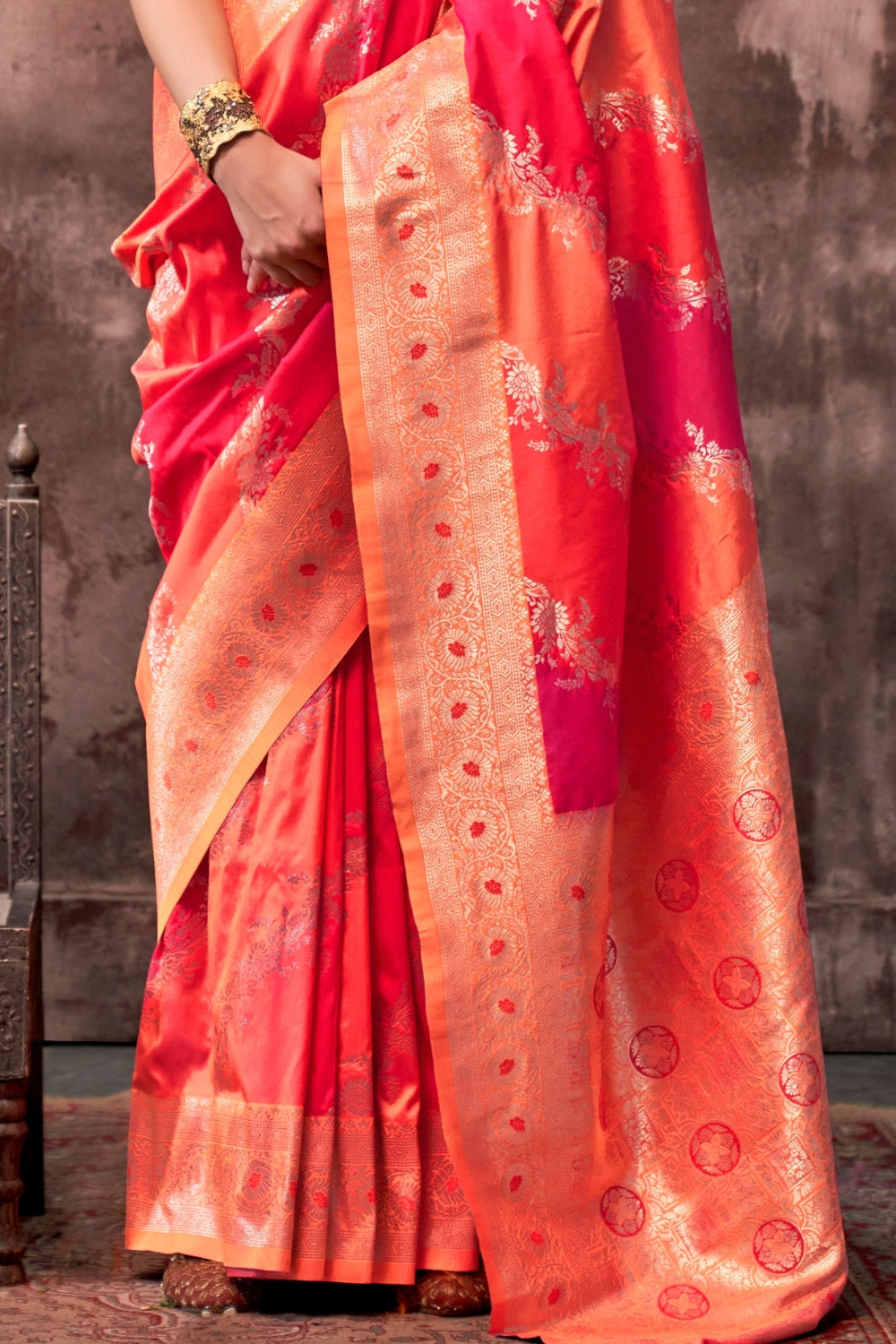 Vermilion Orange and Gold Rangkaat silk saree with temple borders, intricate zari pallu, and traditional wedding styling. Handloom drape perfect for wedding functions and engagement or muhurtham, styled with mogra, antique jewelry, and regal stance. This image captures the side angle view showcasing blouse styling and zari border detail, ideal for visualizing festive elegance, designer appeal, and modern styling inspiration. Perfect for online shoppers seeking detailed previews before purchase, enhancing sa