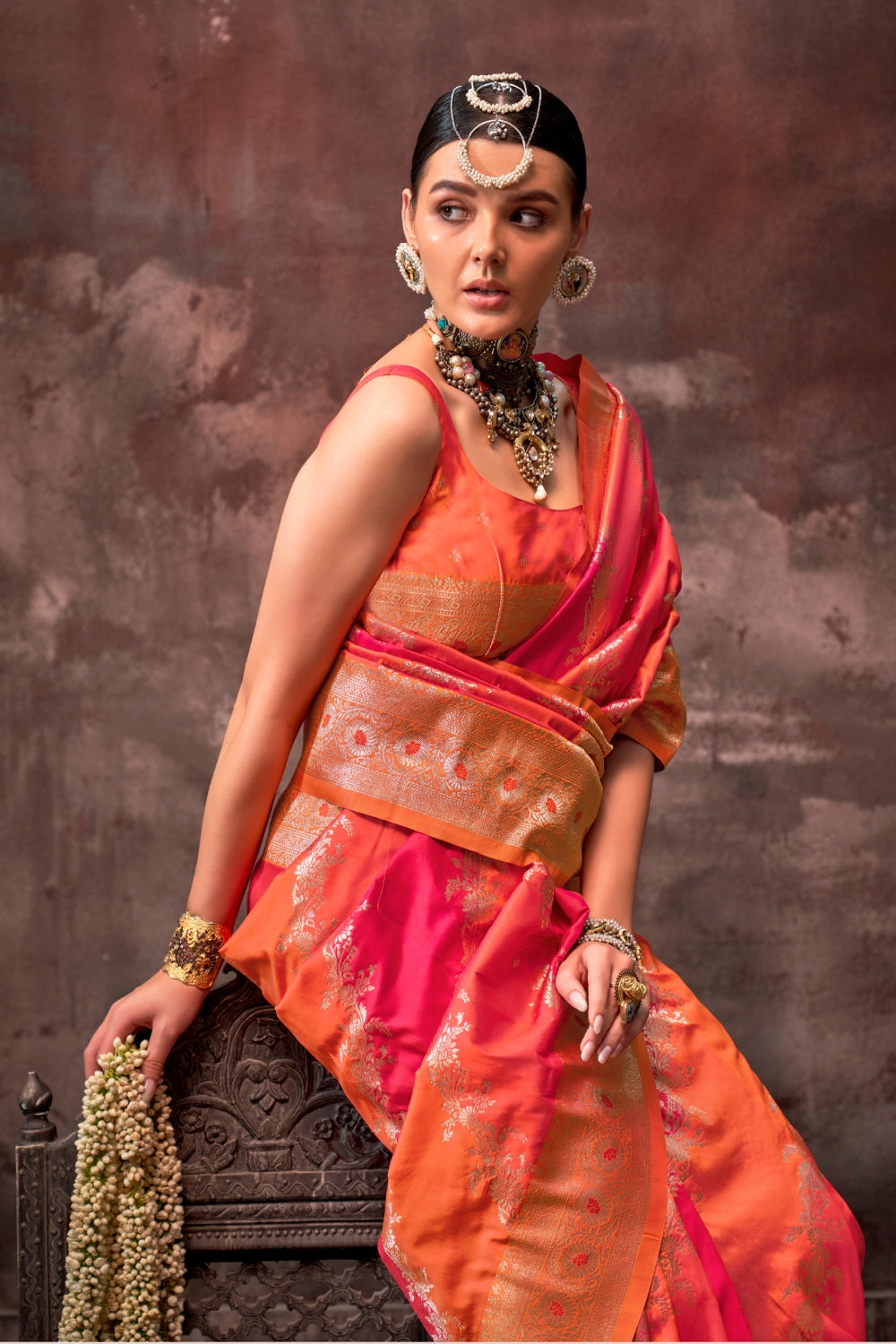 Vermilion Orange and Gold Rangkaat silk saree with temple borders, intricate zari pallu, and traditional wedding styling. Handloom drape perfect for wedding functions and engagement or muhurtham, styled with mogra, antique jewelry, and regal stance. This image captures the zoomed texture view illustrating fabric weave and print clarity, ideal for visualizing festive elegance, designer appeal, and modern styling inspiration. Perfect for online shoppers seeking detailed previews before purchase, enhancing sar