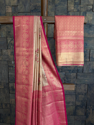 Pink and beige saree with intricate patterns on a stone wall background