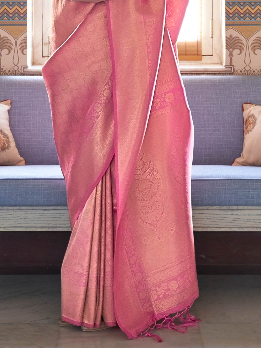 Graceful rose pink festive saree with golden zari border, jacquard weave and unstitched blouse. Soft silk Kanjivaram drape in pink with traditional gold designs for ceremonial grandeur.