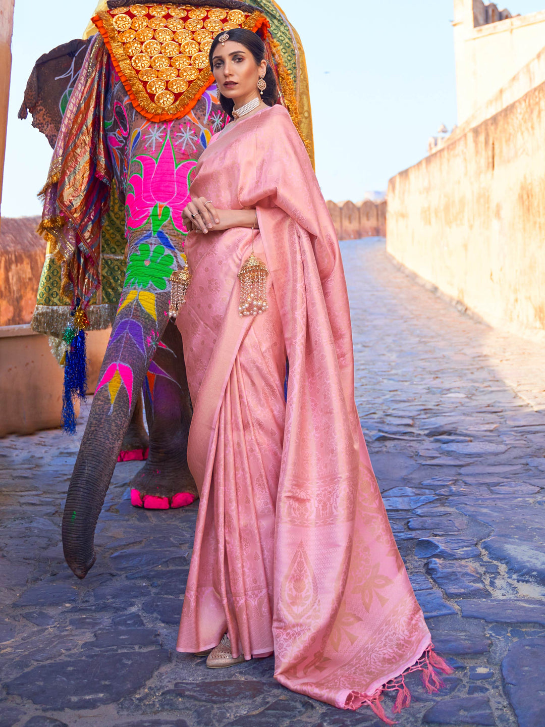 Rose Pink Kanjivaram Silk Saree with golden zari, traditional motif pallu, festive wear highlight. Lustrous silk rose pink saree with golden detailing, ideal for traditional weddings or poojas.